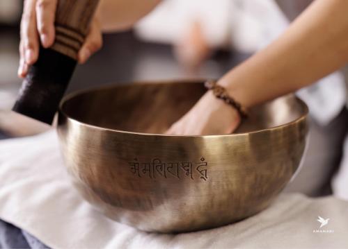 a woman is standing in a metal bowl on a table at Amanaki Thao Dien in Ho Chi Minh City