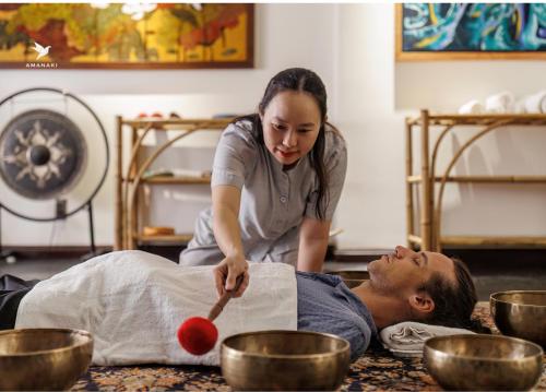 a woman cutting a mans back with a red ball at Amanaki Thao Dien in Ho Chi Minh City