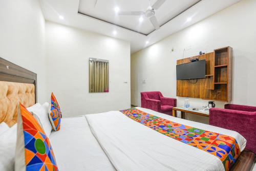 a hotel room with a bed and two chairs at FabHotel Royal Inn in Chandīgarh