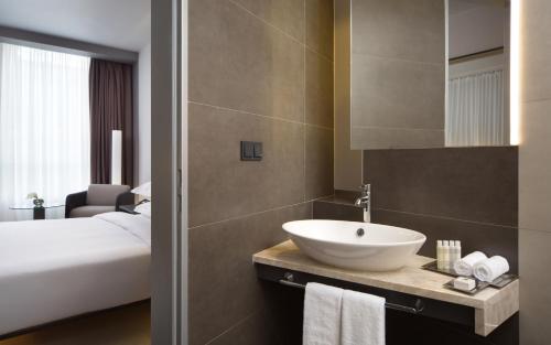 a bathroom with a sink and a bed and a mirror at Four Elements Ekaterinburg in Yekaterinburg