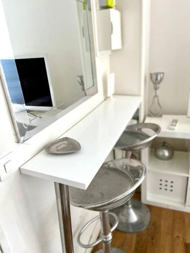 un comptoir blanc avec un miroir et trois tabourets dans l'établissement Studio Gare du Nord Gare de l'Est, à Paris