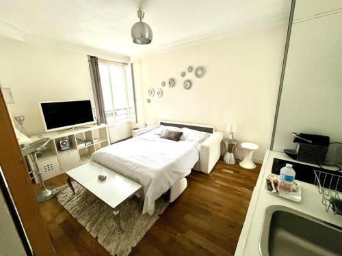 - une chambre blanche avec un lit et une baignoire dans l'établissement Studio Gare du Nord Gare de l'Est, à Paris