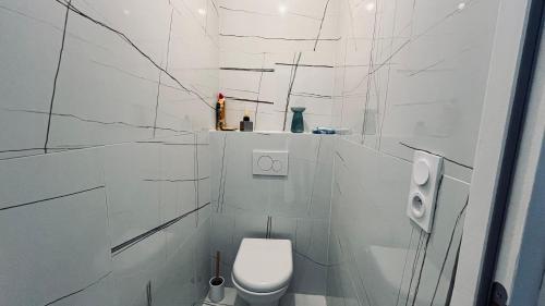 une salle de bains blanche avec des toilettes blanches. dans l'établissement La Tonka, maison neuve proche océan, à Saint-Jean-de-Monts