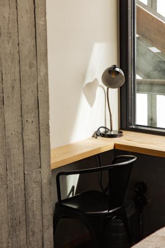 a black chair sitting next to a desk with a lamp at JAM Brussels in Brussels