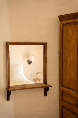 a mirror hanging on a wall with a lamp at Finca Luca Oliva in Zahara de la Sierra