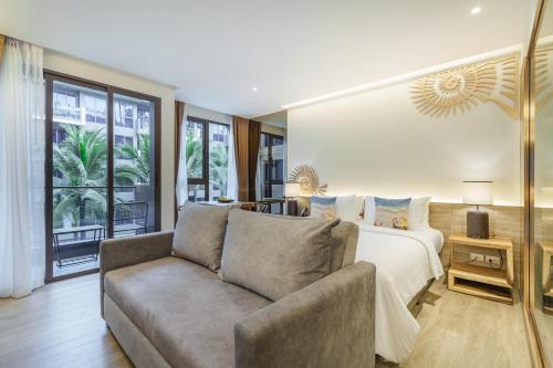 a living room with a couch and a bed at The Marin Phuket Kamala Beach in Kamala Beach