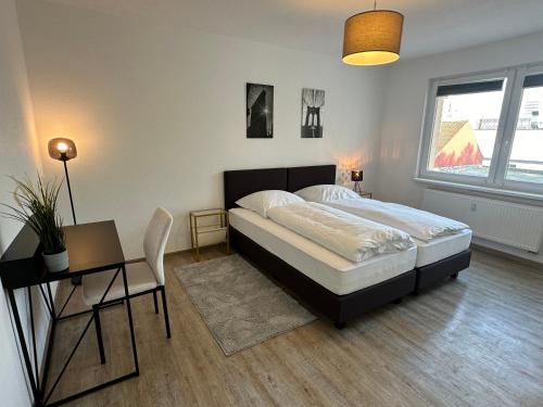 una camera da letto con un letto, un tavolo e una sedia di City-Apartments Hannover ad Hannover