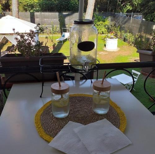 a table with a glass jar and two candles on it at Dimora Casabianca B&B and Family Relais in Tirrenia
