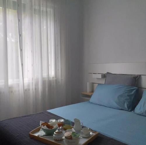 a bed with a tray with bowls of food on it at Dimora Casabianca B&B and Family Relais in Tirrenia