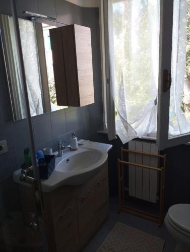 a bathroom with a sink and a toilet and a window at Dimora Casabianca B&B and Family Relais in Tirrenia