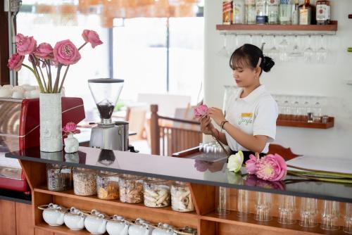 a woman standing behind a counter with flowers at The Jungle in Siem Reap