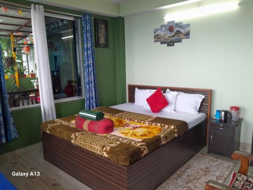 a bedroom with a bed with red pillows at Seven Hills Homestay in Kalimpong