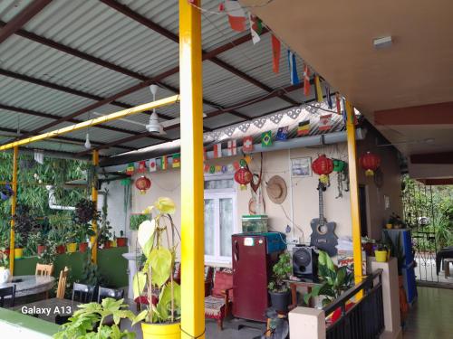 a patio area with yellow columns and plants at Seven Hills Homestay in Kalimpong