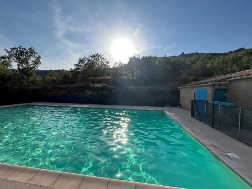 una piscina con el sol al fondo en Maison 3ch - Parc Naturel du Verdon, en Quinson