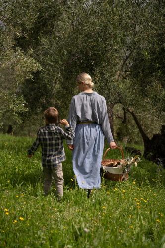 a woman and a child walking through a field at Finca Luca Oliva in Zahara de la Sierra