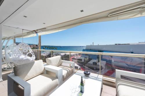 Elle comprend un balcon doté d'un mobilier blanc et offrant une vue sur l'océan. dans l'établissement 1-Br Apartment on the Croisette Palais des Festivals, à Cannes