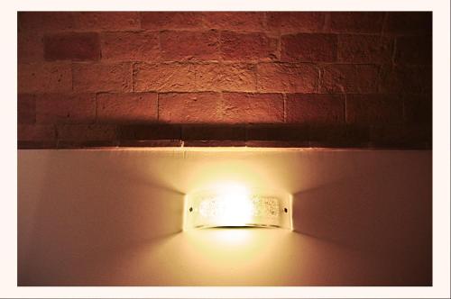 a light on a wall next to a brick wall at B&B La Voce della Luna in San Vito Chietino