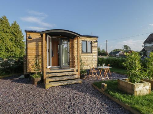 a tiny house with a porch and a table at Willow in Kemble