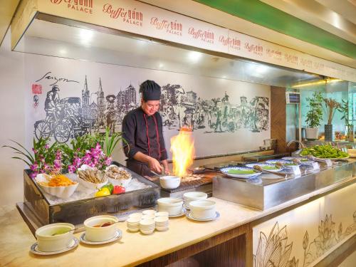 a chef preparing food in a restaurant kitchen at Palace Hotel Saigon in Ho Chi Minh City