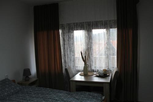 a bedroom with a bed and a table and a window at Temački konaci in Pirot