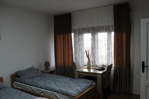 a bedroom with two beds and a table and a window at Temački konaci in Pirot