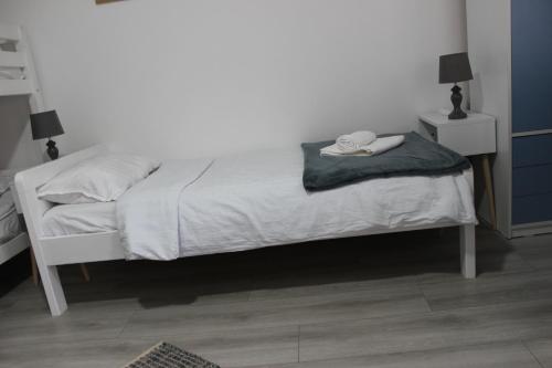 a bedroom with a white bed with a hat on it at Temački konaci in Pirot