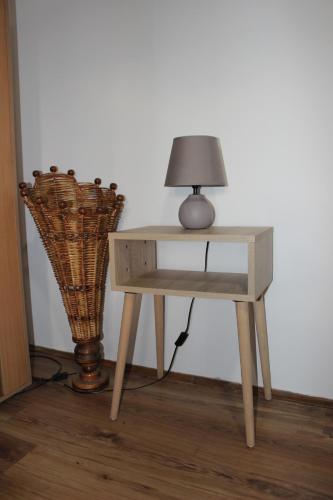 a table with a lamp on it next to a vase at Temački konaci in Pirot