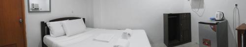 a white bed with two pillows in a room at Pacifico Seaside Lodge in Moalboal