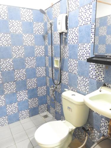 a blue and white bathroom with a toilet and a sink at Pacifico Seaside Lodge in Moalboal