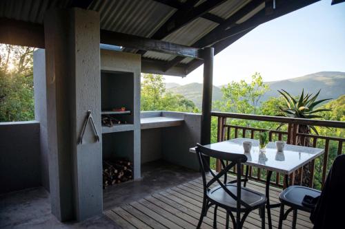 a patio with a table and chairs on a deck at Matatane Camp - Babanango Game Reserve in Nkwalini
