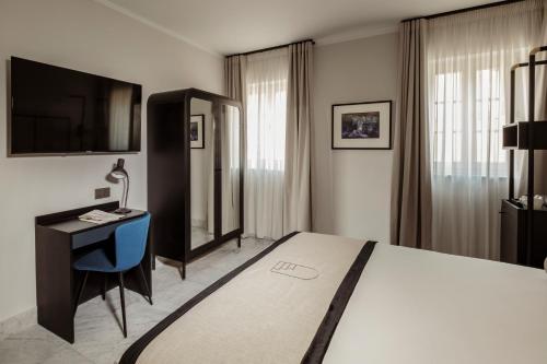 a bedroom with a bed and a desk and a television at San Karlu in Valletta
