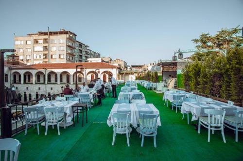 a row of white tables and chairs on a balcony at Bayazhan Hotel ve Restaurant in Gaziantep