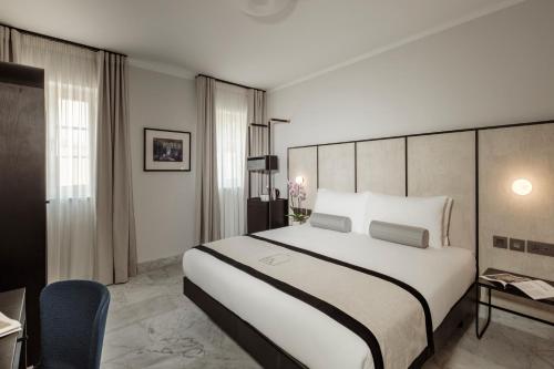 a hotel room with a large bed and a chair at San Karlu in Valletta