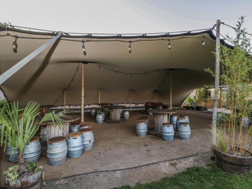 a tent with potted plants in barrels under it at Hazel in Cirencester