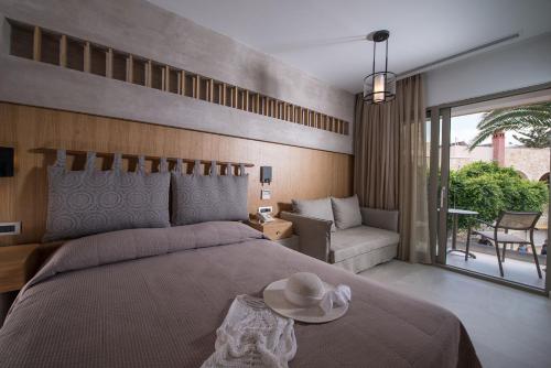 a bedroom with a large bed with a hat on it at Cactus Beach Hotel in Stalida
