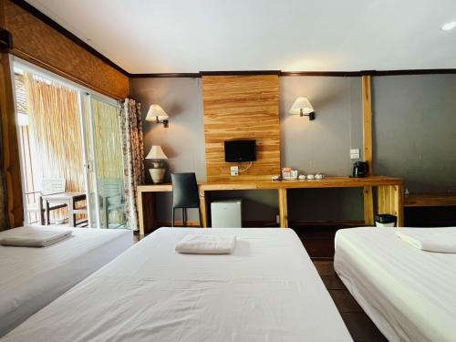 a bedroom with two beds and a desk and a tv at The Hub Erawan Resort in Chongsadao