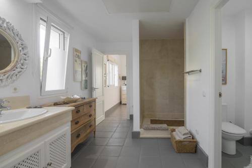Un baño blanco con lavabo e inodoro. en Villa Bella Vida, en Benalup-Casas Viejas