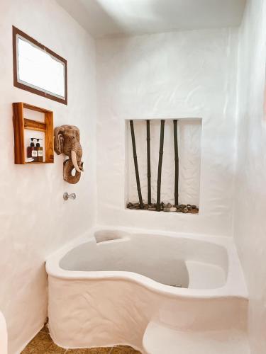 a white bathroom with a tub and an elephant statue at The Hub Erawan Resort in Chongsadao