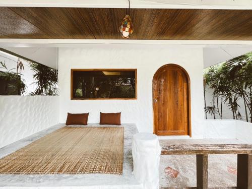a living room with a table and a wooden door at The Hub Erawan Resort in Chongsadao