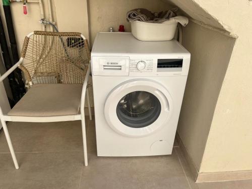 a washing machine and a chair in a room at Ca Erika in Aldaia