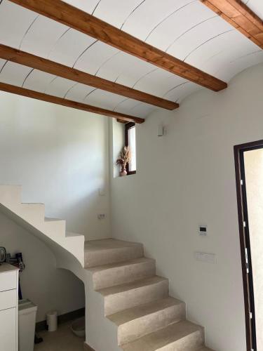 a staircase in a house with wooden ceilings at Ca Erika in Aldaia