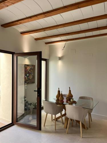 a dining room with a glass table and chairs at Ca Erika in Aldaia