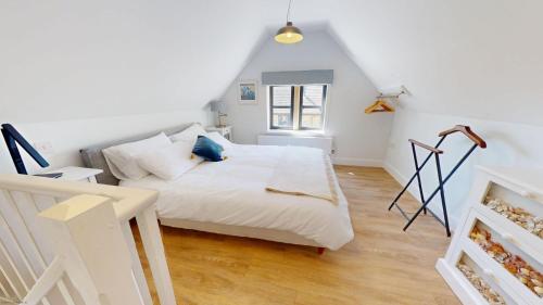 a bedroom with a white bed and a window at The Sculptors Studio in Long Hanborough