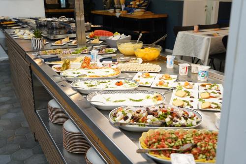 a buffet line with many plates of food on it at Spirit of Herzl Hotel הרוח של הרצל in Jerusalem