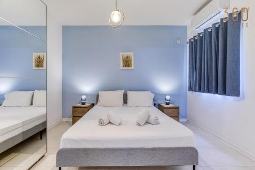 a bedroom with a bed and a mirror at Stylish 3BR Apt with panoramic balcony in Qawra by 360 Estates in St Paul's Bay