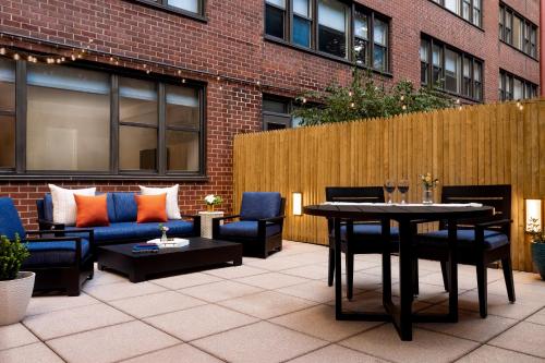 a patio with couches and a table and chairs at The Gardens Sonesta ES Suites New York in New York