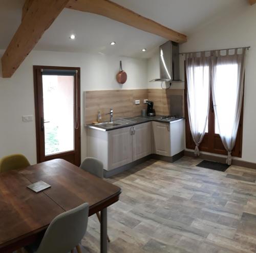 une cuisine avec une table en bois et une salle à manger dans l'établissement Angeline's Gîtes, à Mercurol
