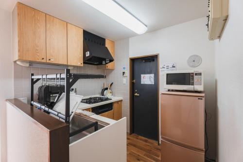 a small kitchen with a sink and a refrigerator at LT Shinjuku West in Tokyo