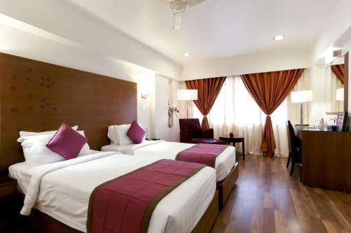 a hotel room with two beds and a desk at Best Western Ramachandra in Visakhapatnam