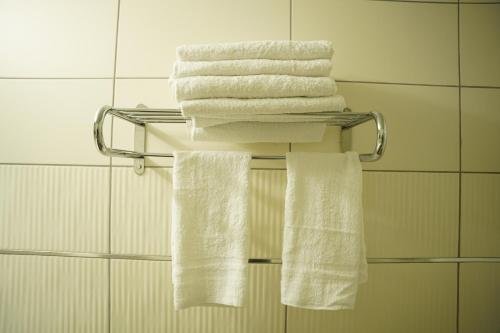 a group of towels on a towel rack in a bathroom at Spirit of Herzl Hotel הרוח של הרצל in Jerusalem